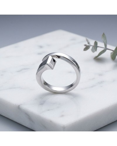 Bague homme en argent rhodié CLOU, design moderne avec motif en forme de nuage sur surface argentée, posée sur marbre blanc.