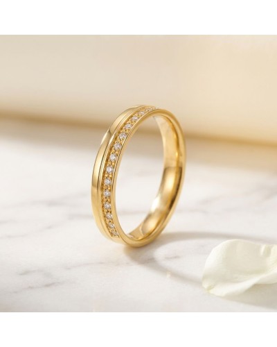 Alliance serti grain de 16 diamants femme en or sur doigt, close-up brillante sur peau claire.