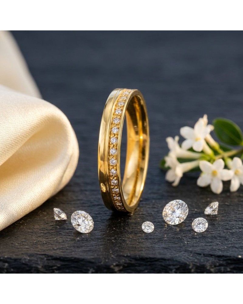 Alliance serti grain de 17 diamants homme en or, bague or jaune ornée de diamants sur fond sombre avec fleurs blanches à côté.
