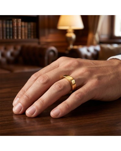 Alliance de forme carrée homme en or: doigt portant bague épaisse dorée sur table en intérieur élégant.