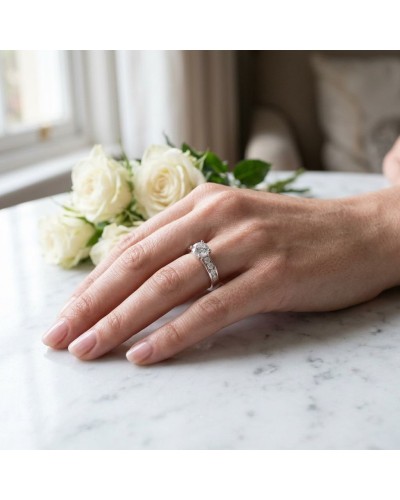 Alliance ATHENA: bague solitaire avec diamant central sur doigt, anneau pavé en or, bouquet de roses blanches en arrière-plan.