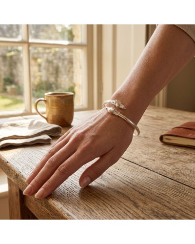 Bracelet DUO LUSITANIENS en argent mat et brillant rhodié porté au poignet, visible sur une main posée sur une table en bois.