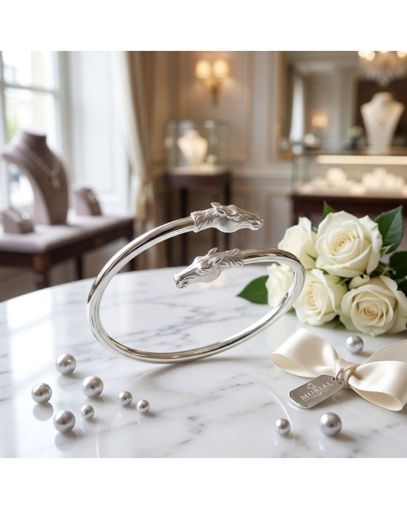 Bracelet Duo Arabes en argent mat et brillant rhodié avec têtes de cheval, posé sur table avec roses blanc et perles.