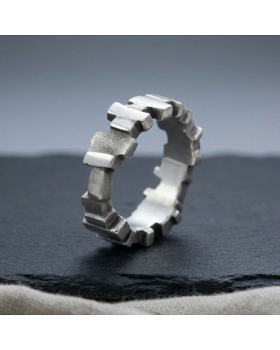 Alliance Blade Homme: bague argentée géométrique en segments, posa sur fond sombre.