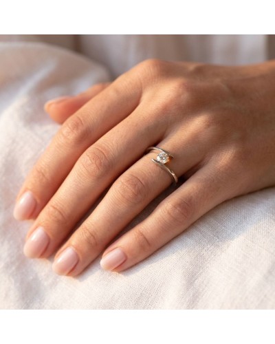 Alliance ONDINE femme en or: doigt féminin portant une bague dorée avec pierre scintillante, sur fond clair.