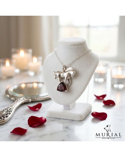 Pendentif magique en argent avec pendentif en forme de chien stylisé et pierre rouge en goutte, sur collier posé sur présentoir.