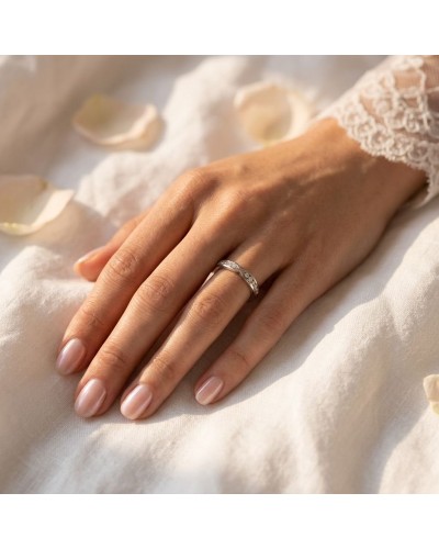 Alliance ARI femme en or: bague fine ornée de petits diamants portée sur doigt féminin, peau claire, délicat motif en or.