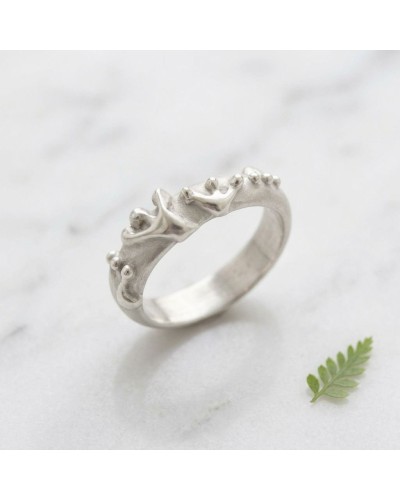 Alliance GRENOUILLE femme en or: alliance argentée avec motif grenouille sculptée, petits reliefs, posé sur marbre avec feuille