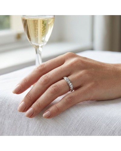 Alliance MÉLUSINE femme en or: bague sertie de diamants portée sur une main féminine, verre de champagne en arrière-plan.