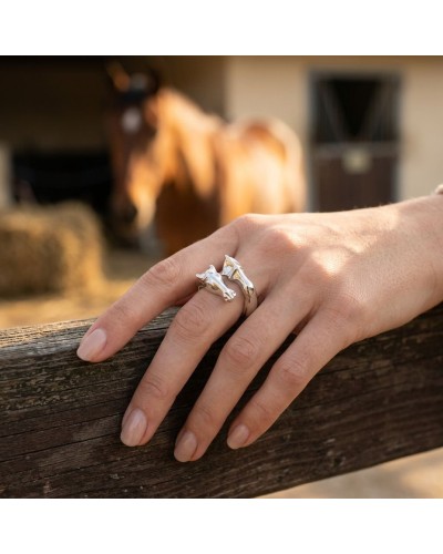 Bague ROCCIO en argent, portée sur le doigt sur fond de clôture en bois avec cheval en arrière-plan.