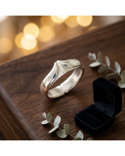 Alliance BUFFLE homme en or: bague masculine lisse en or jaune posée sur une table, avec boîte à bijoux et feuillage décoratif.