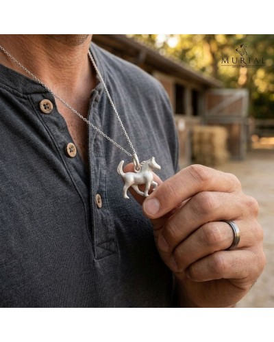 Pendentif HOPE en forme de cheval, argenté, suspendu à une chaîne sur une chemise sombre; contexte équestre noble.