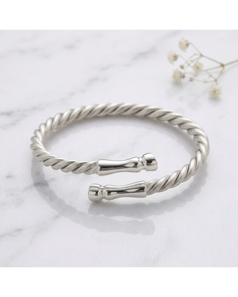 Bracelet torsadé argenté avec extrémités bouchonnées, style bangle ouvert et poli, posé sur marbre. ALT: bracelet GALOPADE argen