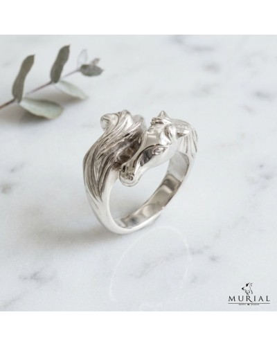 Bague argentée ISADORA femme en forme de cheval, design sculpté et liséré ondulé sur bague ouverte, sur fond marbré.