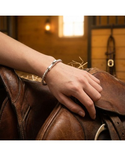 bracelet HANSE en argent rhodié porté sur le poignet d'une personne près d'un cheval avec selle en cuir, ambiance équestre, styl
