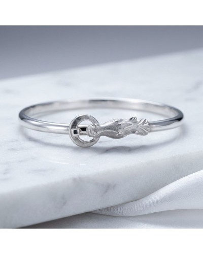 Bracelet ARABE en argent mat et brillant rhodié, avec fermoir rond et motif cobra élégant sur marbre.