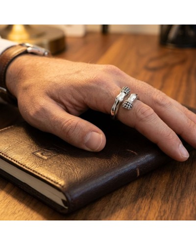 Bague PIAFFER homme en argent rhodié avec 42 oxydes noirs portée sur le doigt au-dessus d’un carnet en cuir.