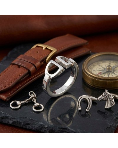 Bague homme en argent rhodié avec design moderne, posée près d'un bracelet en cuir et d’un compas, sur une plaque noire.