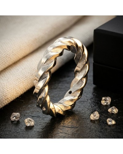Alliance torsadée en or deux-ton doré argenté, bague homme 4 mm, posée sur surface sombre avec pierres décoratives.