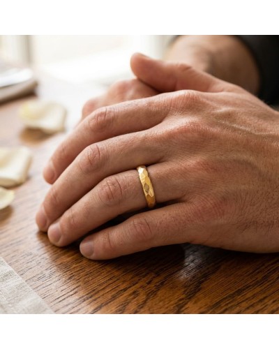 Alliance FLASH 4 mm homme en or: close-up d'une main masculine portant une bague dorée à facettes sur le doigt.