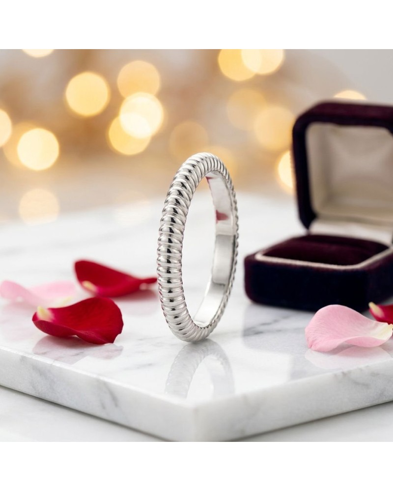 Alliance ELEKTRA 3 mm homme en or: bague argentée torsadée sur plateau marble avec pétales et boîte jewelry en arrière-plan.