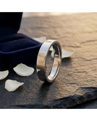 Alliance MATRIX lisse 5 mm homme en or argenté, bague de mariage sur pierre sombre avec pétales blancs.