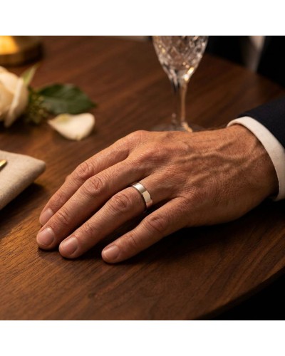 Alliance MATRIX lisse 5 mm, homme, doigt porté sur table en or, vue proche avec bague argentée.