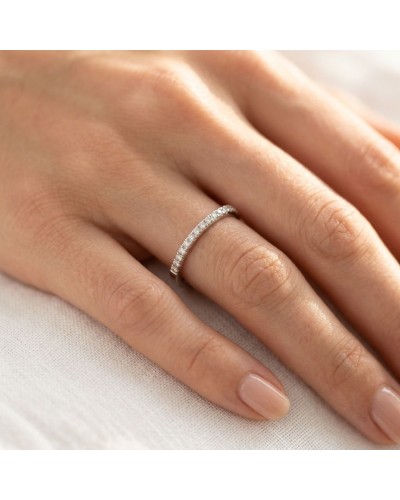 Alliance femme en or avec pierres 2 mm: bague délicate pavée de diamants sur doigt feminin.