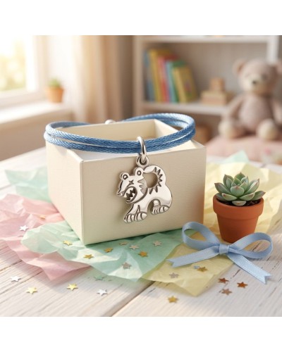 Bracelet BB TIGRE en argent avec pendentif tigre, sur cordon bleu, présenté sur boîte blanche, décor pastel et petite plante suc