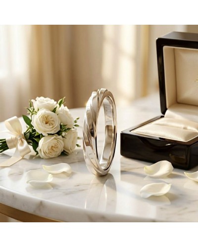 Alliance ENTRELACE Femme en or: bague délicate en or près d’un bouquet de roses et d’un écrin ouvert sur une surface en marbre.