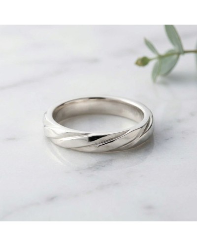 Alliance Homme en or argenté avec motif torsadé, trônant sur une surface claire.