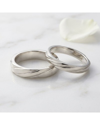 Alliance ENTRELACE Femme en or – bagues assorties en bijoux argentés, design torsadé élégant sur fond marbre.