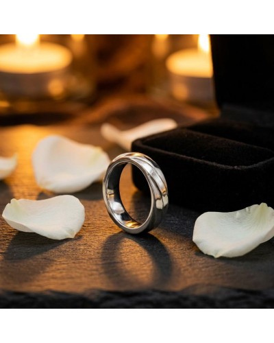 Alliance Homme en or argenté posé sur une surface sombre avec pétales blancs et boîte noire côte à côte.