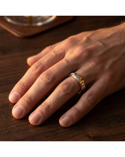 Alliance Homme en or: doigt portant une bague plata or riche motif croisé sur fond bois.