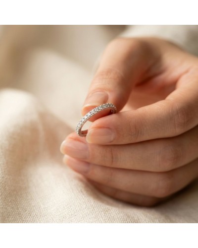 Alliance Modeste empierrée Femme en or: chevalière délicate ornée de petits diamants portée entre les doigts.