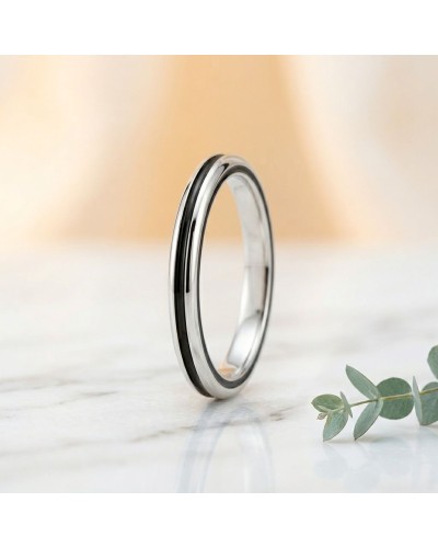 Alliance homme en or argenté, bague circulaire minimale avec bords brillants, posé sur marbre avec feuillage.