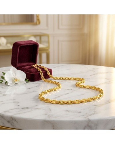 Chaîne forçat limée en Or jaune 18k, 1,4 mm, 40 cm, posée sur une table à côté d’un boîtier velvet burgundy.