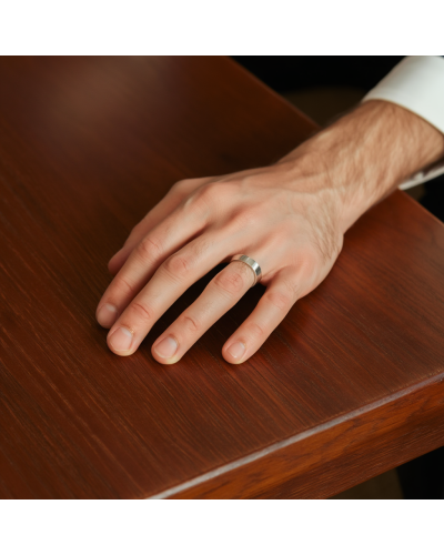 Alliance MATRIX lisse 8 mm homme en or: doigt masculin portant une bague plata/acier sur une table en bois.