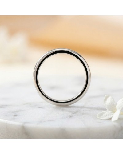 Alliance Modeste Femme en or : bague simple dorée argentée avec intérieur noir, proche d’une fleur blanche.