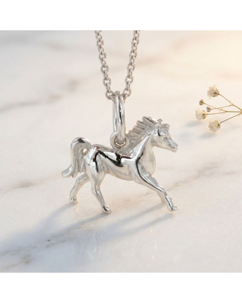 Pendentif en argent LITTLE PACHA: cheval miniature sculpté, chaîne argentée, posé sur surface claire.