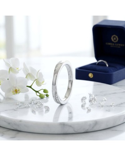 Anneau en platine avec diamants et boîte cadeau bleu foncé; fleurs blanches à côté, pierres brillantes sur marbre. Alliance CROI