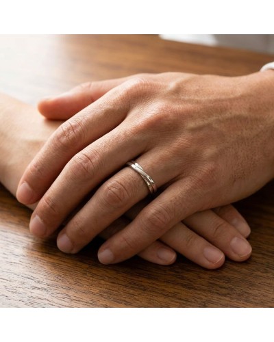 Alliance CROISADE Homme en or: deux mains posées, featuring a silver ring on the ring finger.