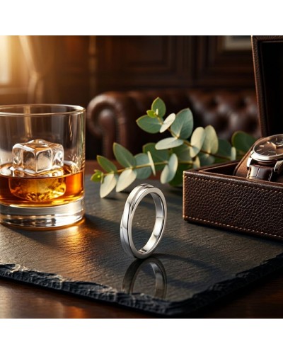 Alliance CROISADE Homme en or: alliance argentée posée sur une plaque sombre, whisky et whisky glass à gauche, montre et étui en