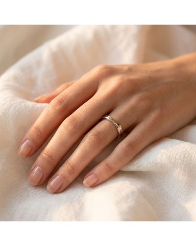 Alliance CROISADE Femme en or: doigt féminin portant une bague dorée, sur tissu clair, prise en gros plan.