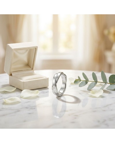 Alliance TRESSE Femme en or: bague argentée élégante près d’un écrin beige sur une table marbrée, feuilles et pétales autour.