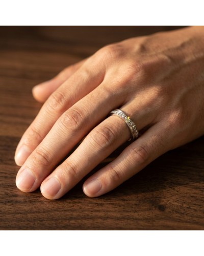 Alliance CROISADE diamants sur le doigt: bague or homme avec pierres scintillantes portée sur une main.