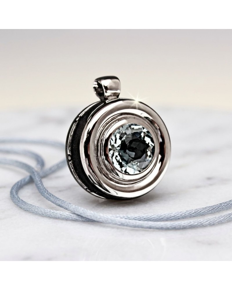 Pendentif BOUEE en métal argenté avec pierre centrale facettée brillante, porté sur une corde gris clair.