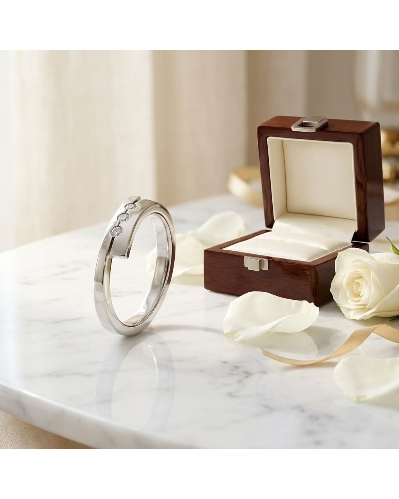 Alliance moderne en argent avec trois diamants et boîte à bijoux en bois, entourée de pétales de rose blancs