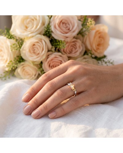 Alliance TOI + MOI 3 diamants Femme en or: bague élégante portée sur la main devant un bouquet de roses crème.