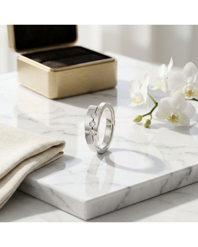 Alliance TOI + MOI 3 diamants Homme en or: bague en argenté avec trois diamants, sur marbre près d’une boîte et des orchidées.